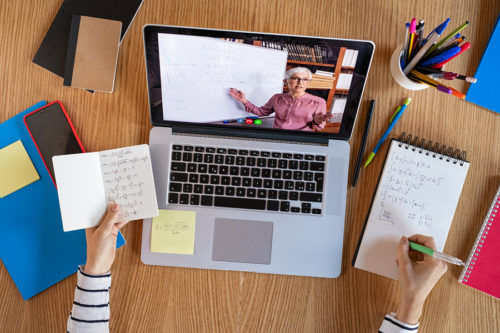 High angle view of video conference with teacher on laptop at home. Top view of girl in video call with personal tutor on computer listening audio course, distance and e-learning education concept.